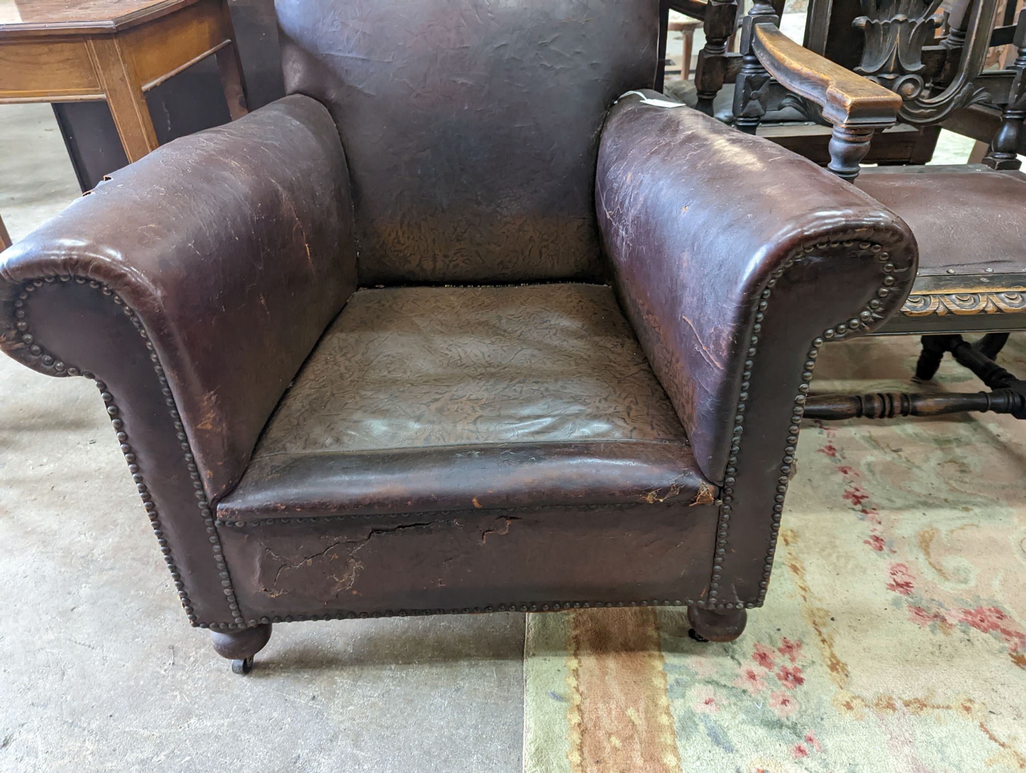 A studded brown leather club armchair, width 86cm, depth 81cm, height 90cm